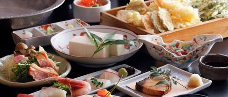 Variedad de platos japoneses, incluyendo sushi, sashimi y tempura.