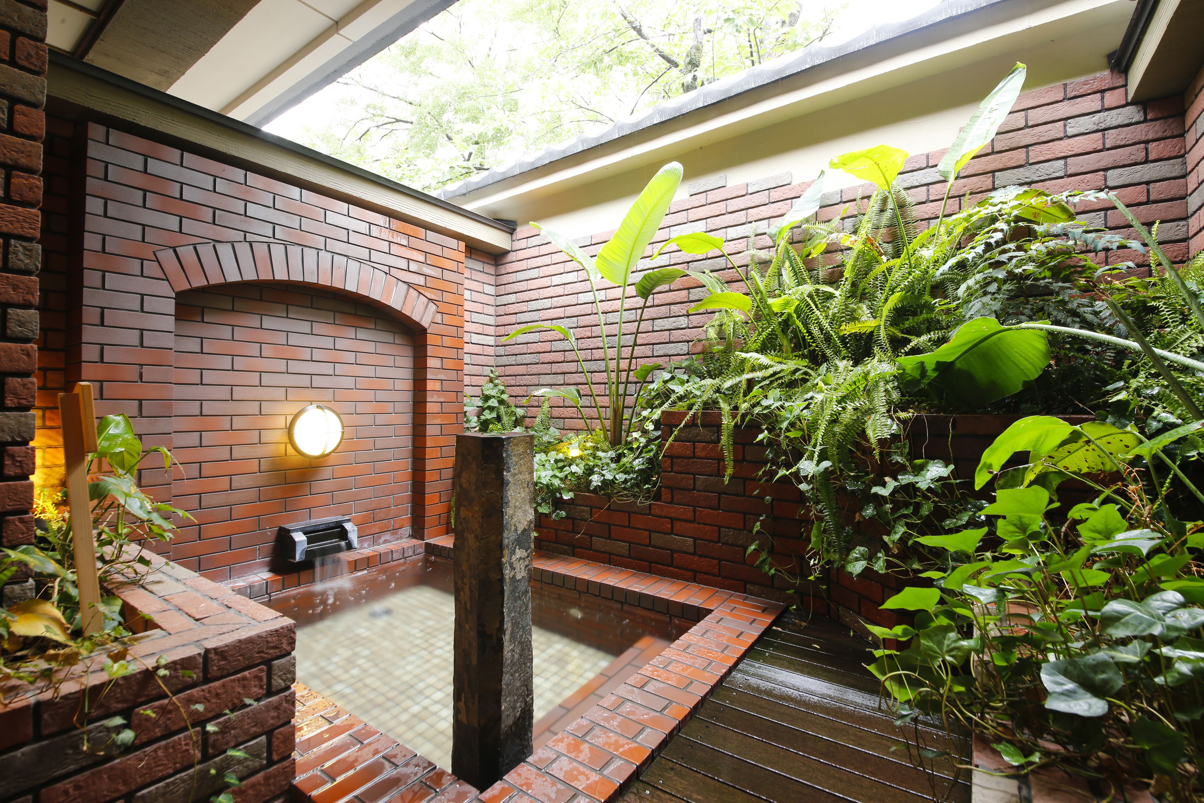 Un muro de ladrillo con una chimenea integrada y una pequeña fuente de agua.