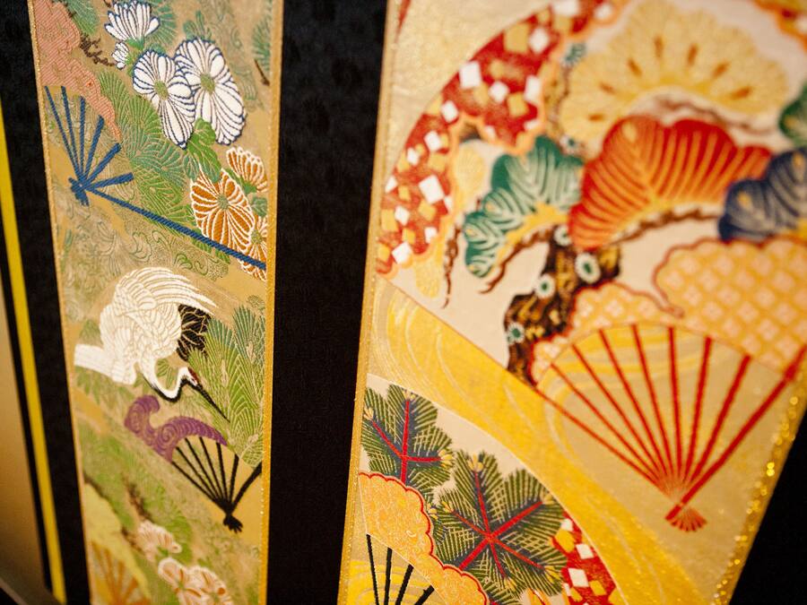 A close-up of a decorative panel with intricate floral and fan designs.