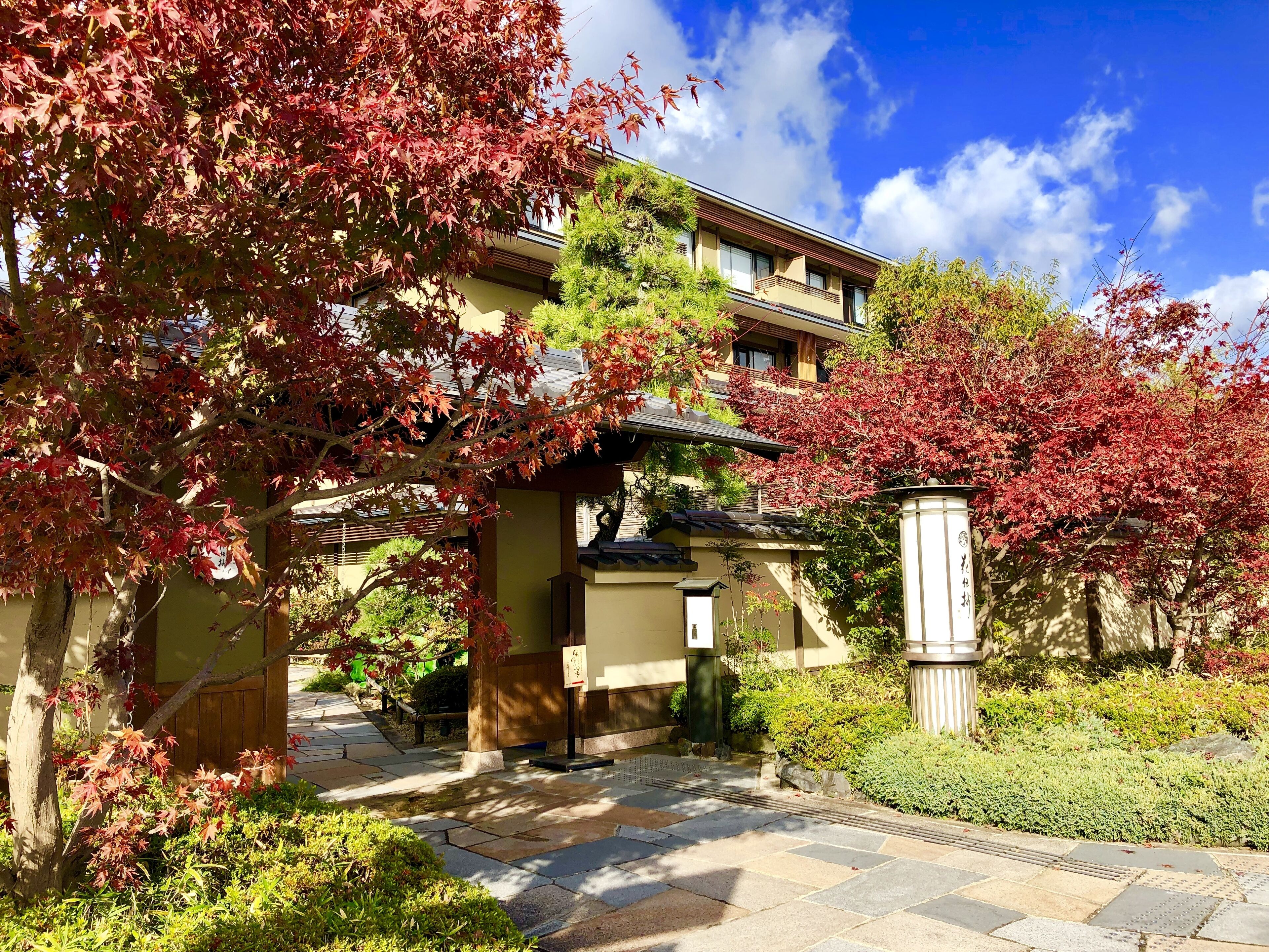 Un edificio tradicional japonés con un camino de piedra que lleva a la entrada.