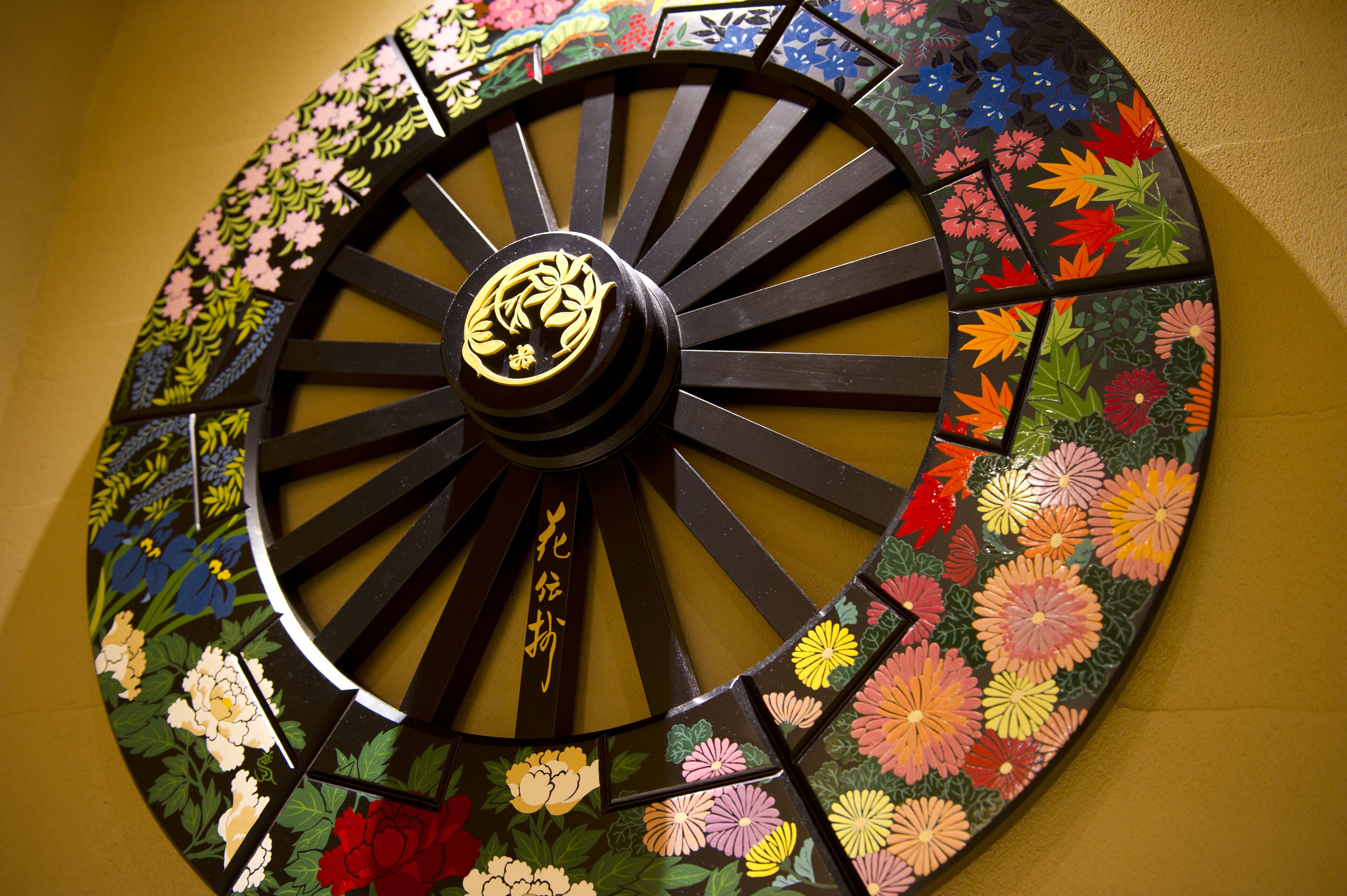 A decorative wheel with floral patterns and Japanese characters.