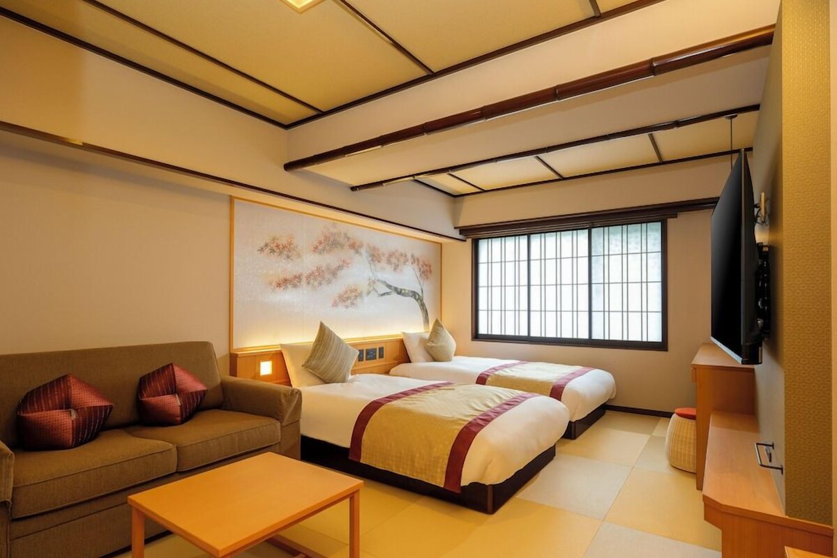 A traditional Japanese-style room with tatami flooring, a low ceiling, and a sliding door.