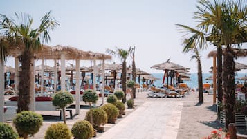 Chaises longues, parasols, serviettes de plage, massages sur la plage