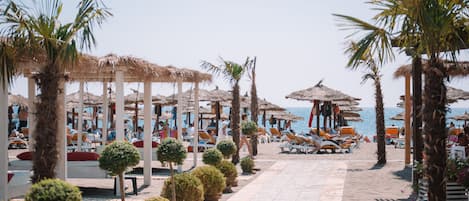 Chaises longues, parasols, serviettes de plage, massages sur la plage