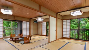 A traditional Japanese room with tatami flooring, sliding doors, and a view of greenery outside. - Kageyu (Isehara)