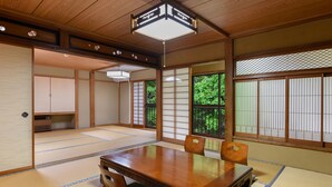 A traditional Japanese room with tatami flooring, a wooden table, and sliding doors. - Kageyu (Isehara)