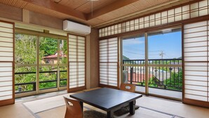 A traditional Japanese room with tatami flooring, a low table, and shoji screens. - Kageyu (Isehara)