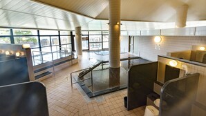 Moderni yleisöwc, jossa on lasiseinä, lattialämmitys ja näkymä ulos.