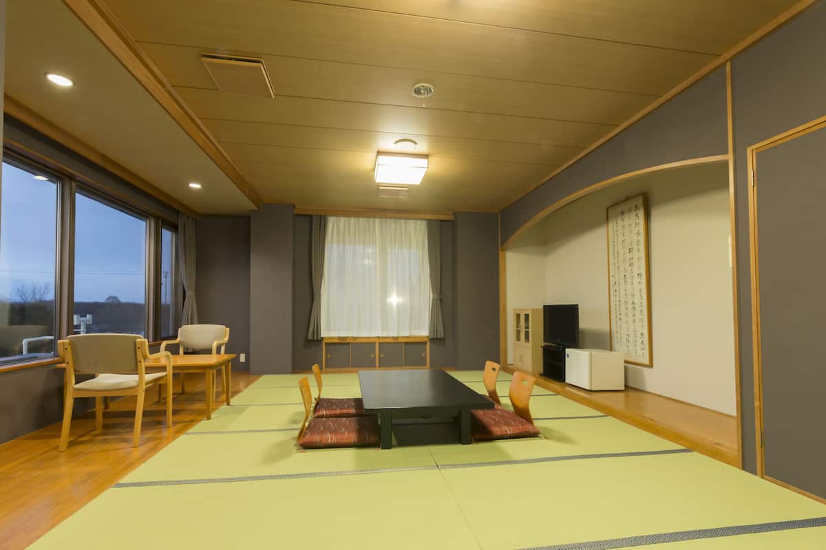 Een traditionele Japanse kamer met tatami vloeren, een lage tafel en houten stoelen.