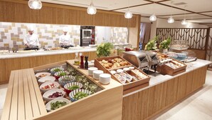 Un buffet proposant une variété de plats et un chef qui prépare les aliments.