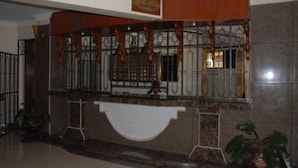 A reception area with a marble counter, a reception desk, and a sign above it.