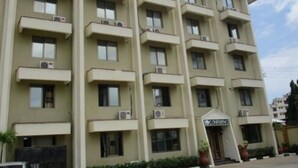A multi-story building with balconies, air conditioning units, and a sign that reads "CONFINES".