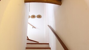 A spiral staircase with wooden steps and a handrail, leading to a landing with a light fixture. - B&B Stradivari (Cremona)