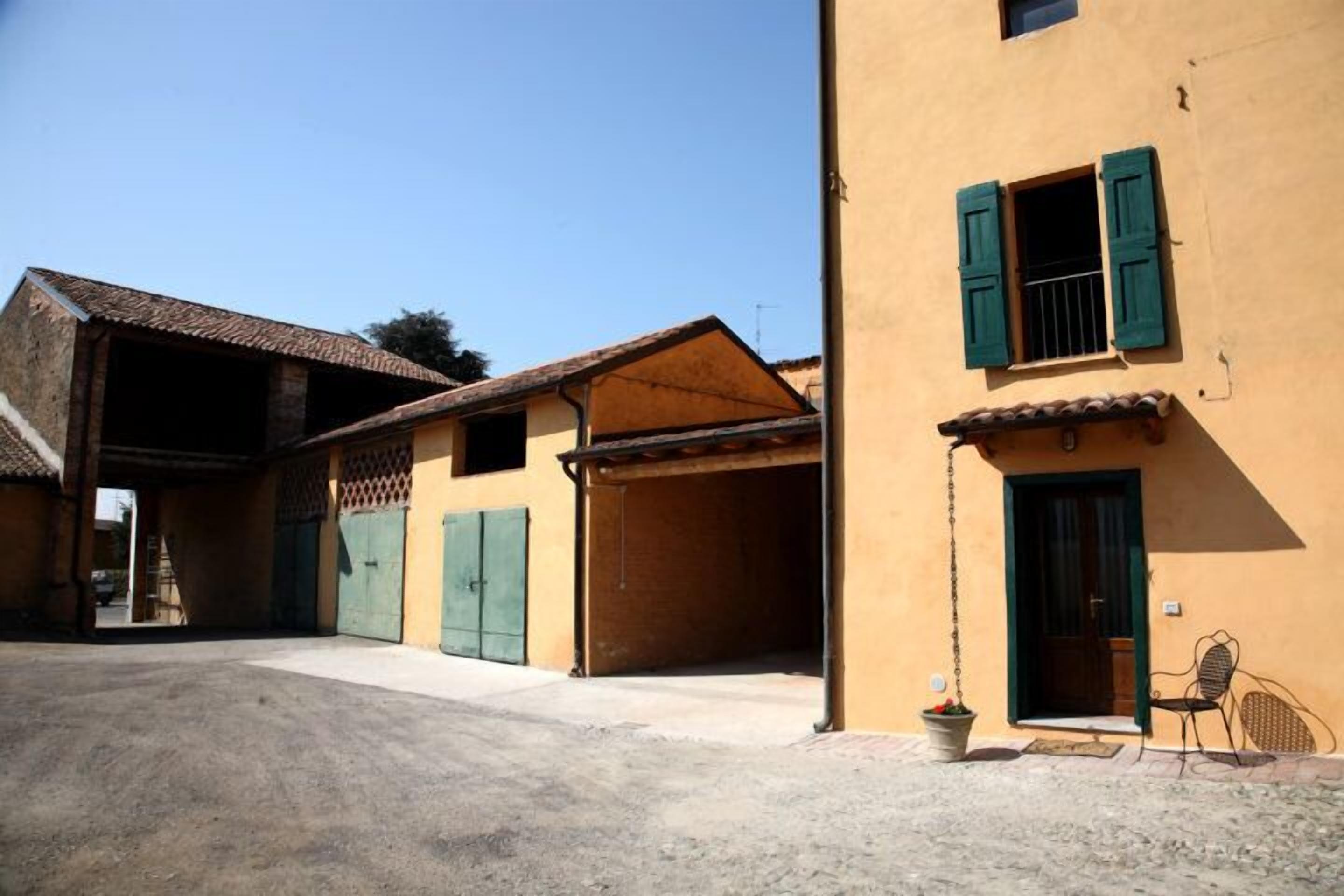 A building with a garage, a covered entrance, and a small outdoor seating area.