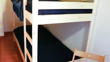 Una cama litera con una escalera de madera y una silla al lado.