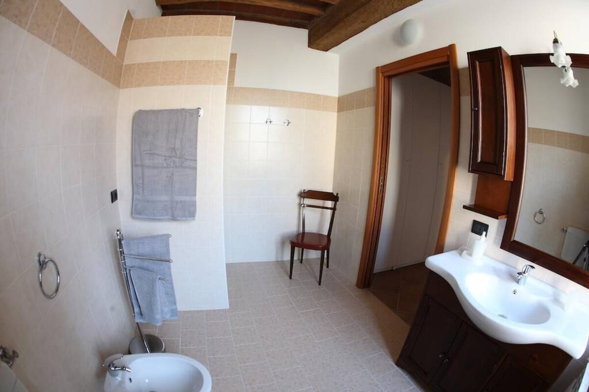 Une salle de bain avec un lavabo, un miroir et une chaise en bois.