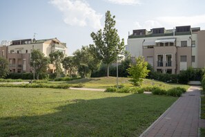 Un quartier résidentiel comprenant des immeubles d’appartements, une pelouse et un chemin piétonnier dallé.