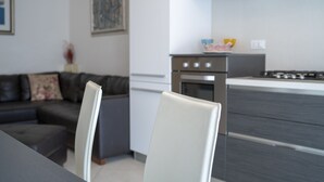 A modern kitchen with a built-in oven and a stainless steel range hood. - Rosmini Serbati (Rimini)