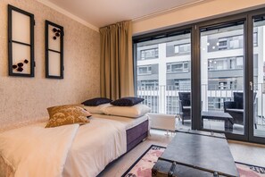 A modern bedroom with a bed, a large window, and a view of the city. - Prague Luxury APTs by Michal&Friends (Prague)
