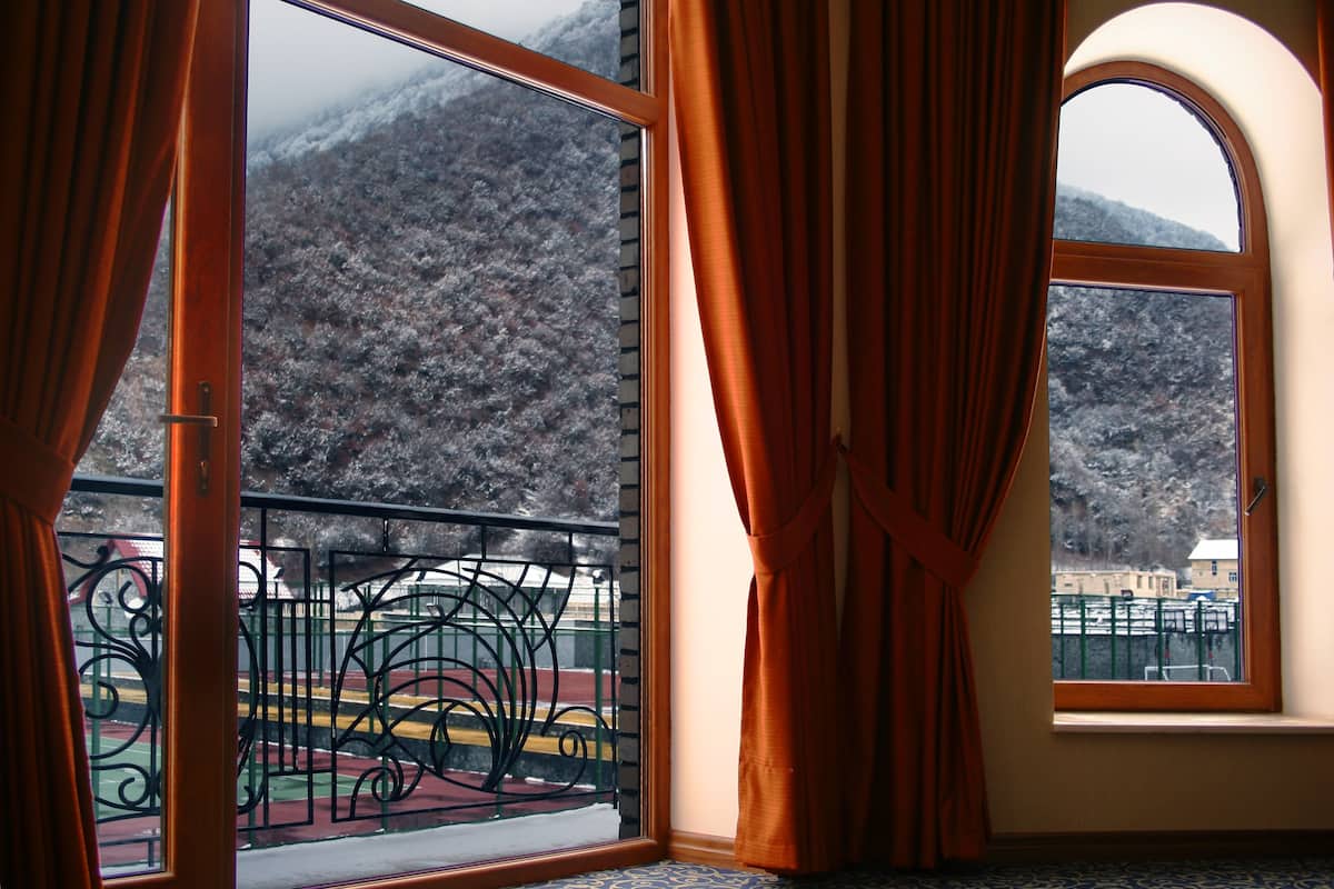 Una habitación con un amplio ventanal con vistas a un paisaje montañoso.