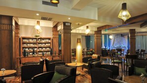 Eine Hotelhalle mit Holzmöbeln, einer Bar und einer Sitzecke mit Tischen und Stühlen.
