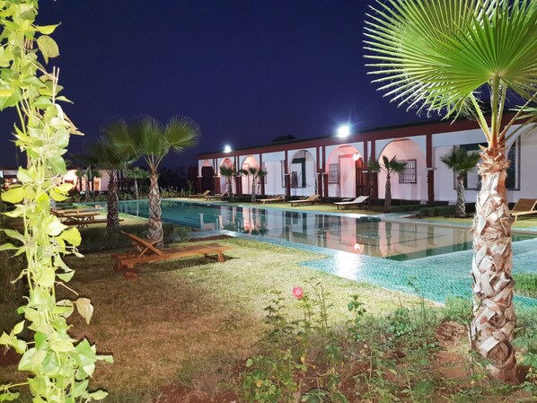 Alberca al aire libre, sombrillas en la alberca y camastros 