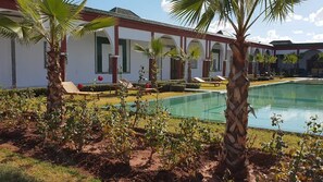 Alberca al aire libre, sombrillas en la alberca y camastros 