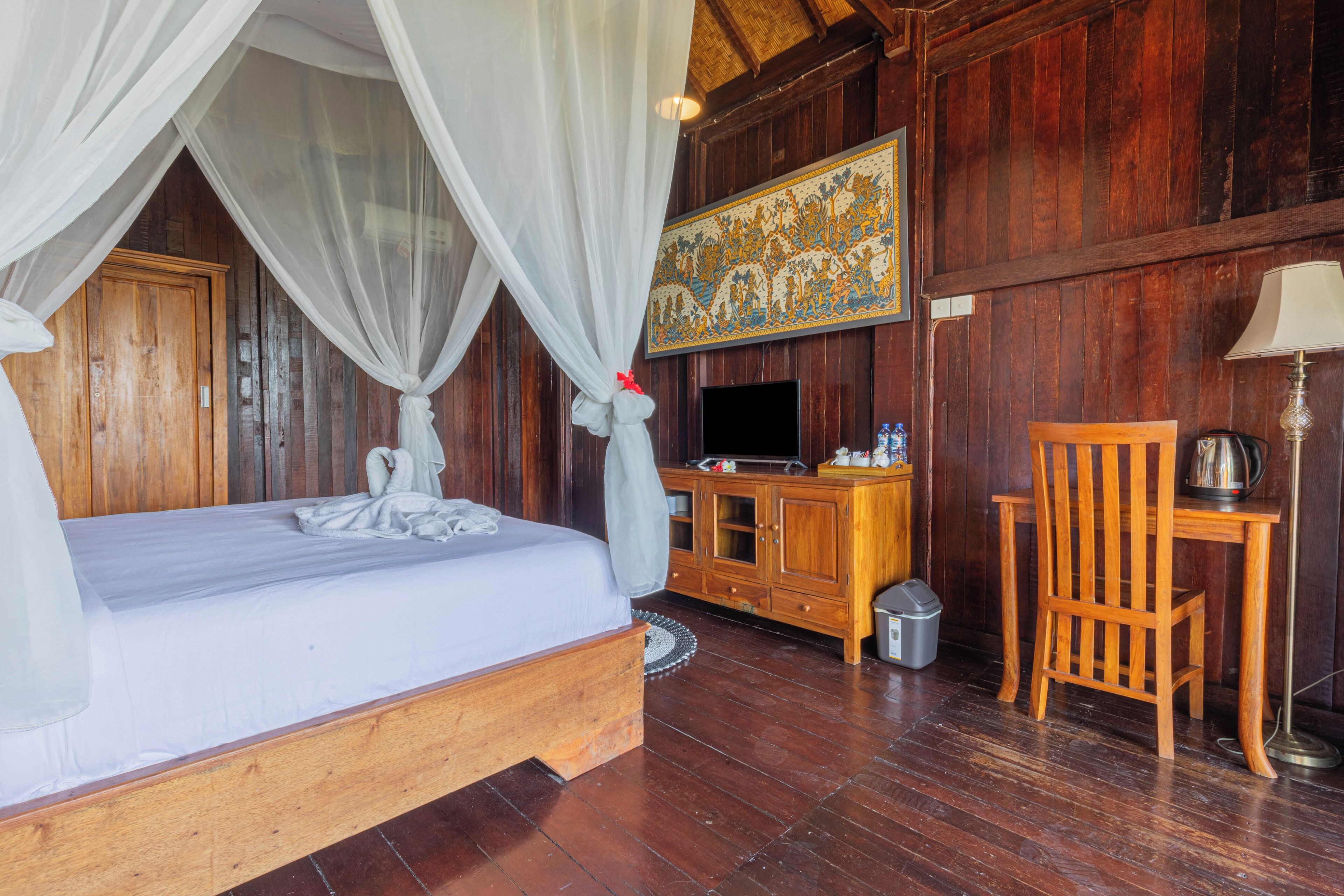 Una habitación de madera con cama, televisor, aparador y silla.