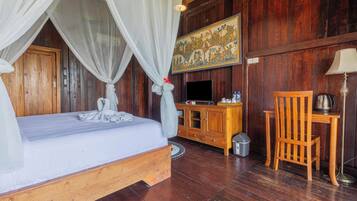 Una habitación de madera con cama, televisor, aparador y silla.