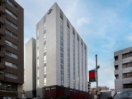 Un edificio alto y moderno con un logotipo destacado en la parte superior.
