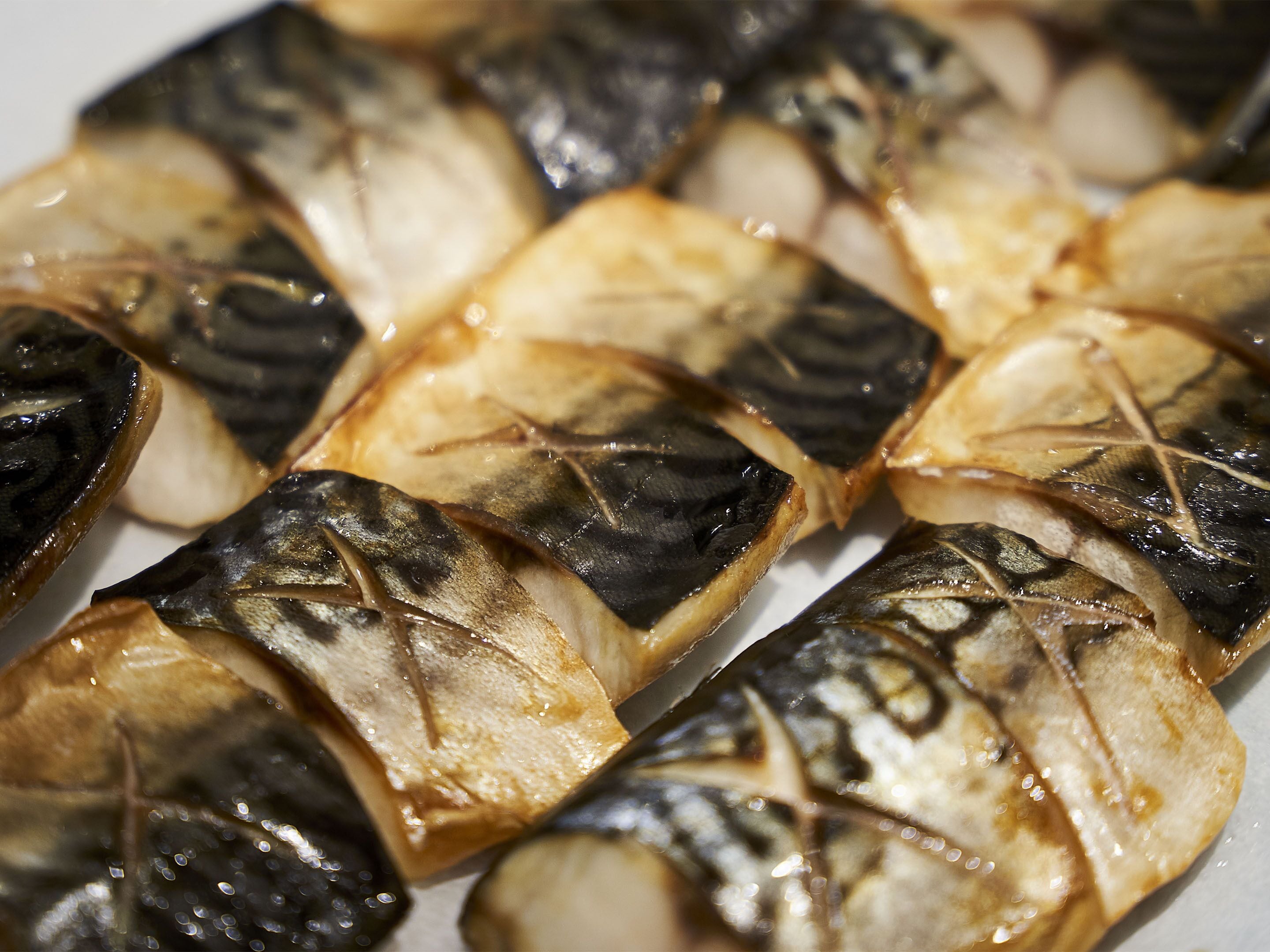 Primer plano de pescado a la parrilla con exterior quemado.