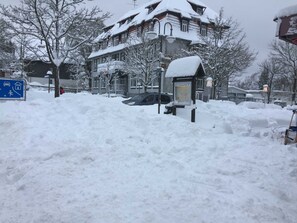 A snow-covered building with a sign indicating a post office and a public restroom.