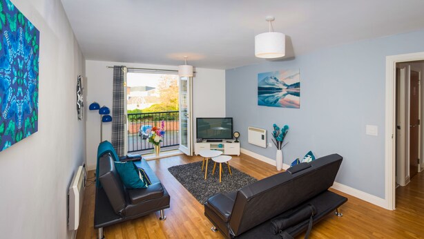 A modern living room with a sofa, a TV, and a balcony with a view. - Grand Central Friar Gate Deluxe (Derby)