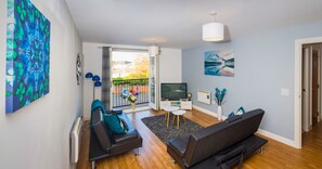 A modern living room with a sofa, a TV, and a balcony with a view. - Grand Central Friar Gate Deluxe (Derby)