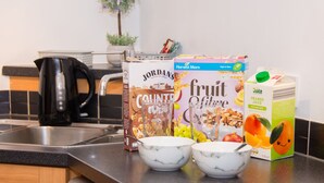 A kitchen counter with a coffee maker, cereal boxes, and a carton of orange juice. - Grand Central Friar Gate Deluxe (Derby)