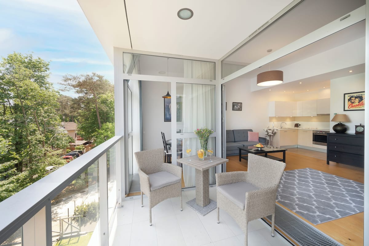 Un apartamento moderno con balcón, comedor y cocina.