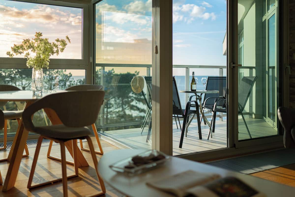 Un comedor moderno con una mesa, sillas y vistas al mar.