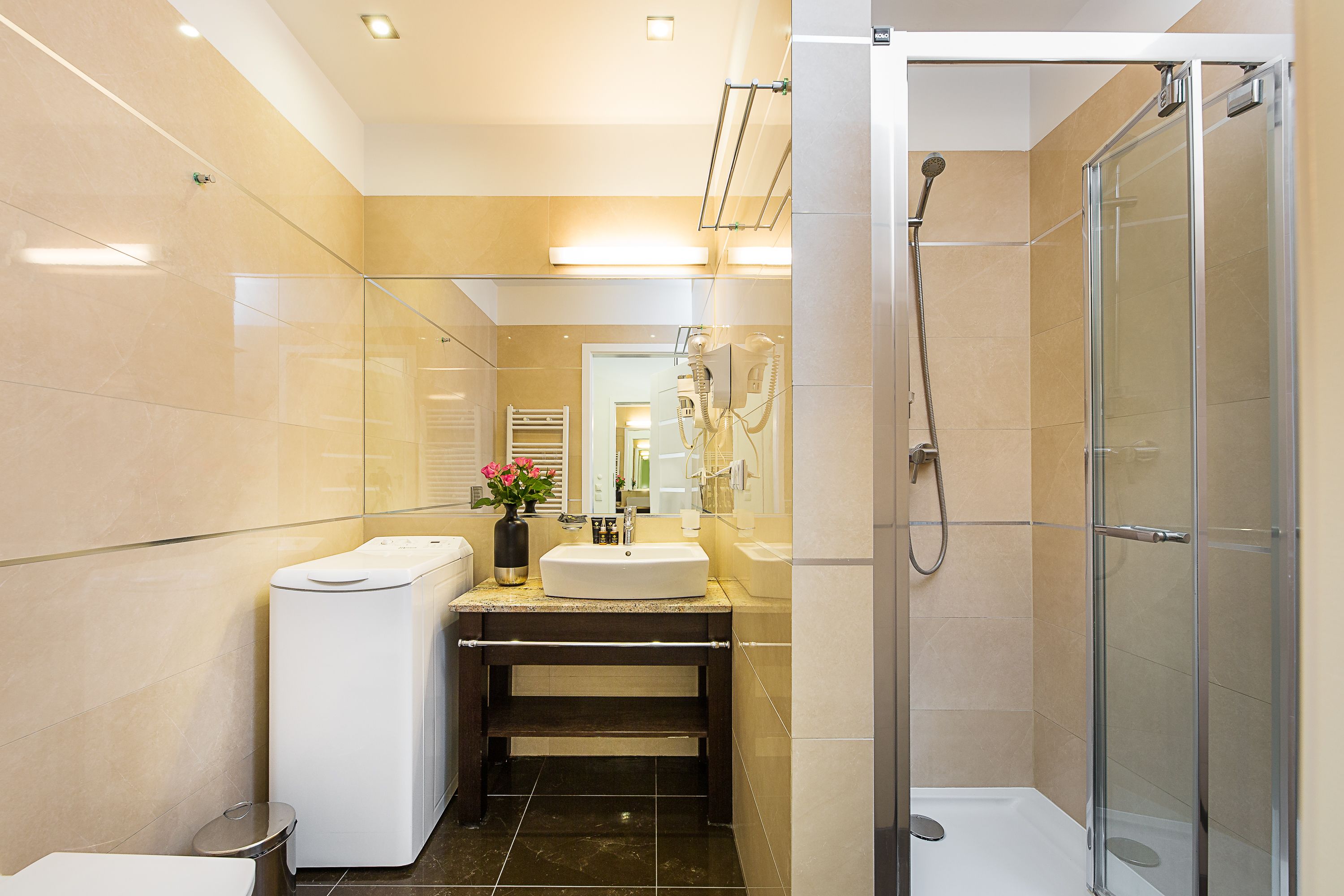 A modern bathroom with a glass shower enclosure, a built-in toilet, and a vanity with a sink.