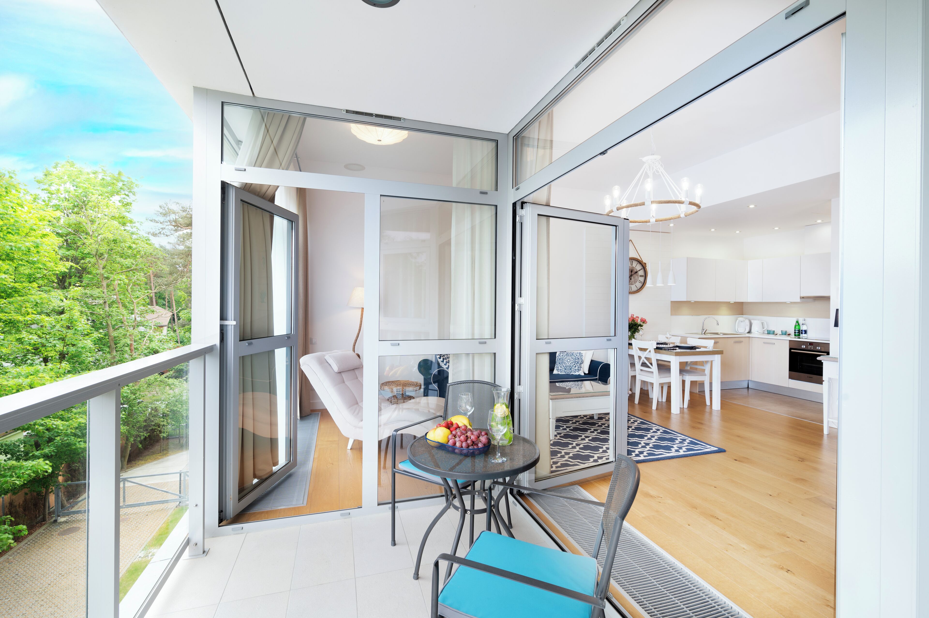 A modern apartment with a balcony, a dining area, and a kitchen.