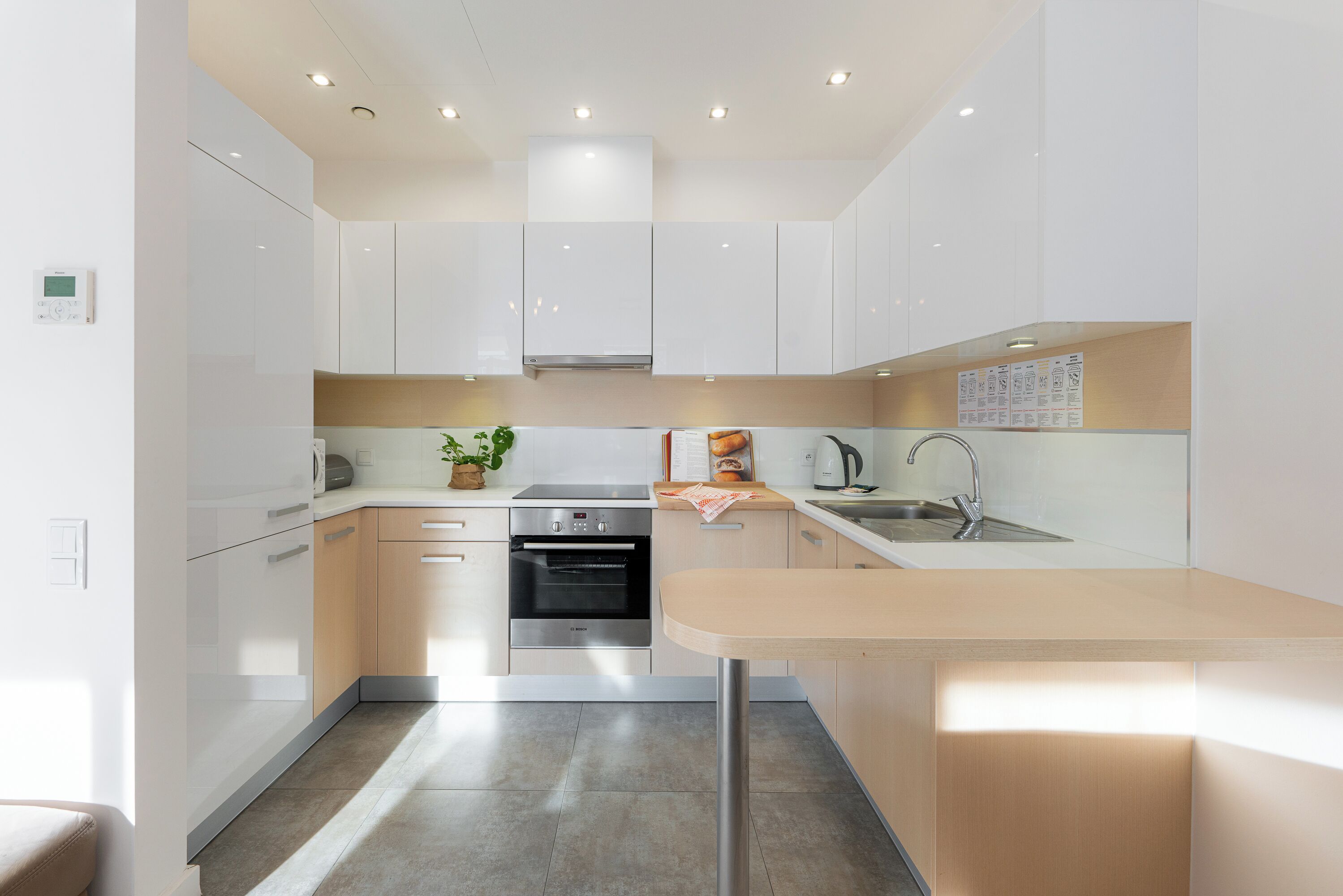 A modern kitchen with white cabinets, stainless steel appliances, and a central island.