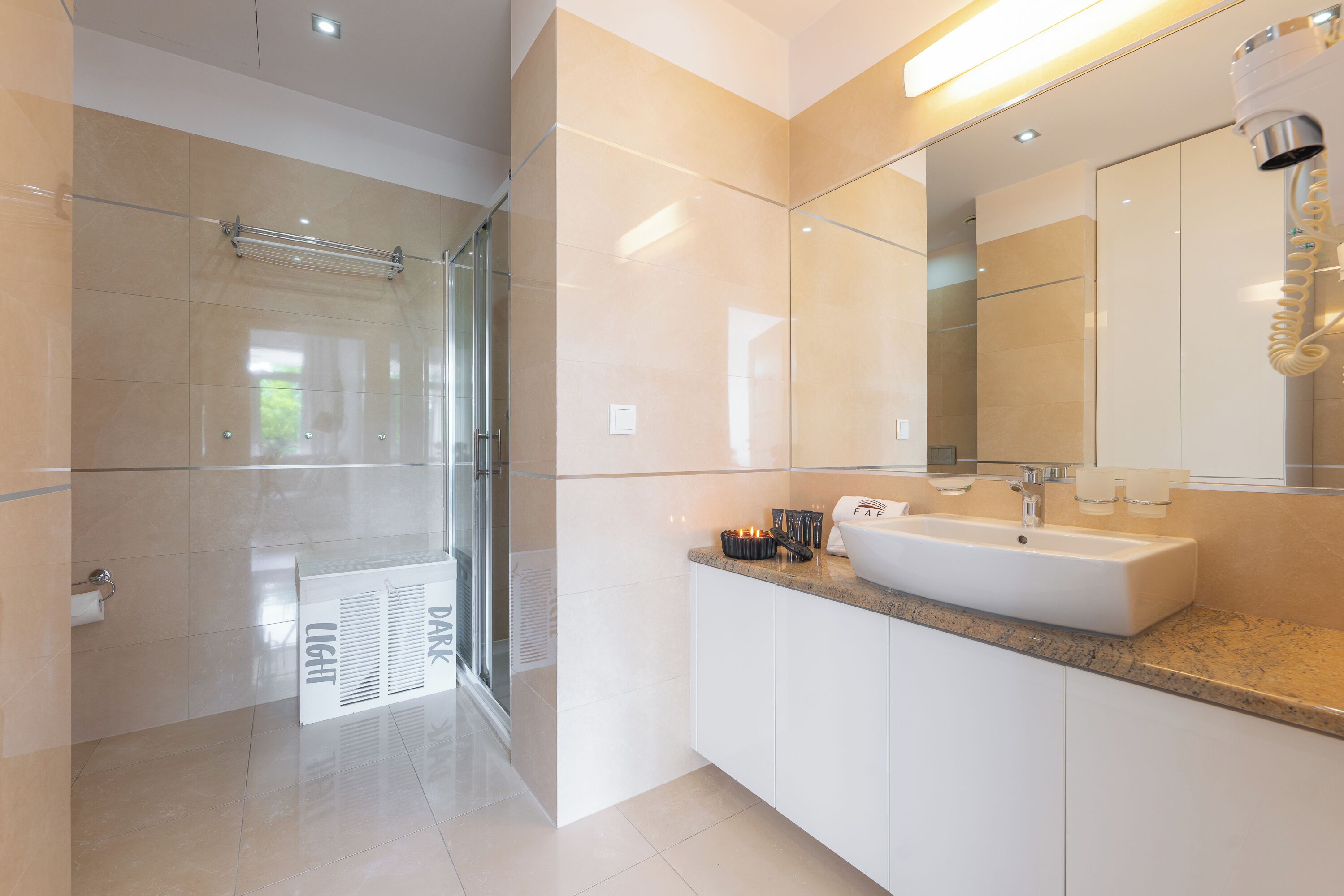 A modern bathroom with a glass shower, a large sink, and a mirror.