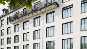 A modern hotel with multiple floors, large windows, and a ground-level entrance with a parking area. - Hotel Schopenhauer Hof (Frankfurt)