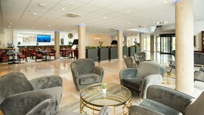 A spacious lobby with modern seating, a bar area, and a large screen. - Hotel Schopenhauer Hof (Frankfurt)