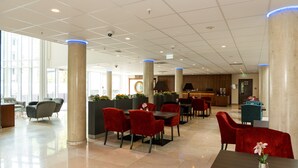 A spacious lobby with a reception desk, red and grey chairs, and a coffee bar. - Hotel Schopenhauer Hof (Frankfurt)