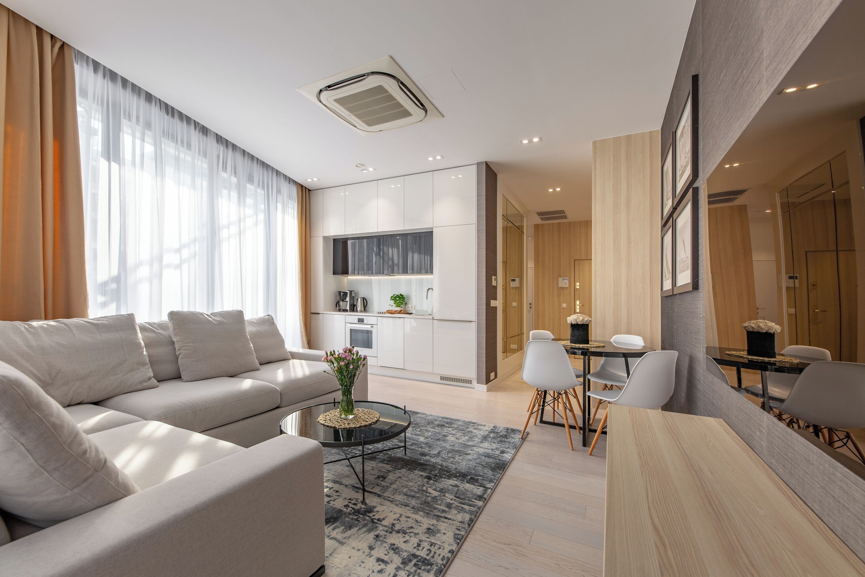 Una sala de estar moderna con sofá, mesa de centro y comedor.