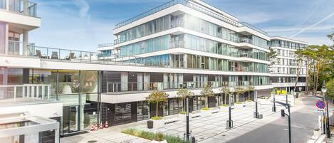 A modern multi-story building with large windows and a flat roof.