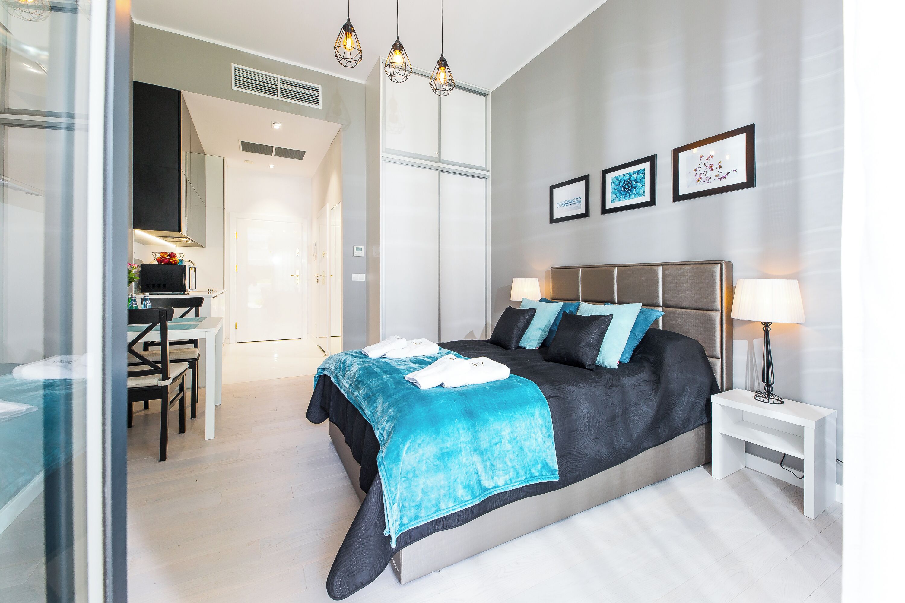 A modern bedroom with a bed, bedside tables, and a desk area.