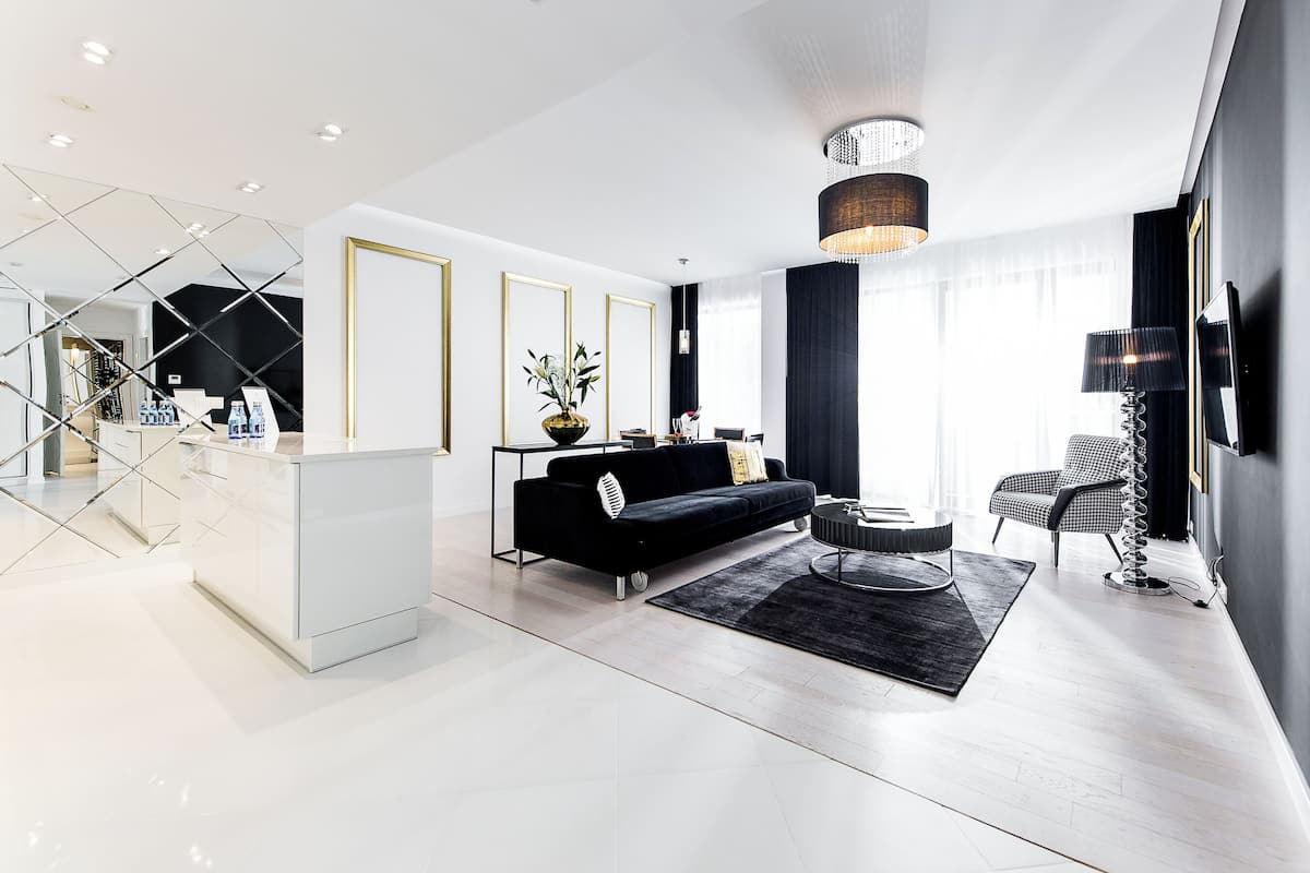 A modern living room with a black sofa, a round coffee table, and a black rug.