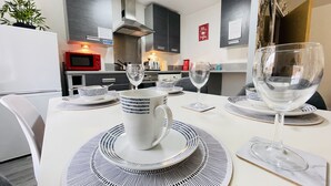 A modern kitchen with a dining area set for two. - Grand Central Littleover Deluxe (Derby)