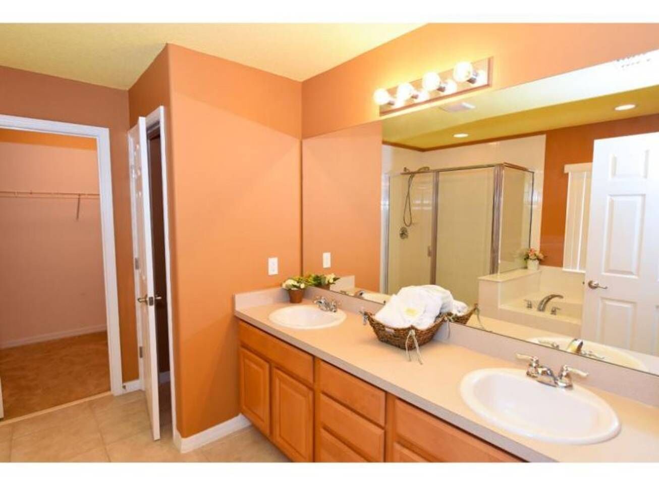 Un baño con dos lavabos, un espejo grande y una ducha.